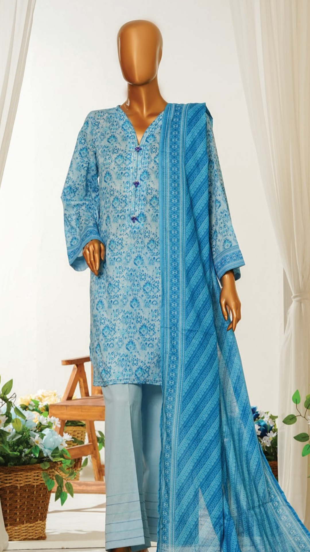 Mannequin wearing MTJ  Beige and red floral dressa blue printed kurta with matching dupatta in a room setting.