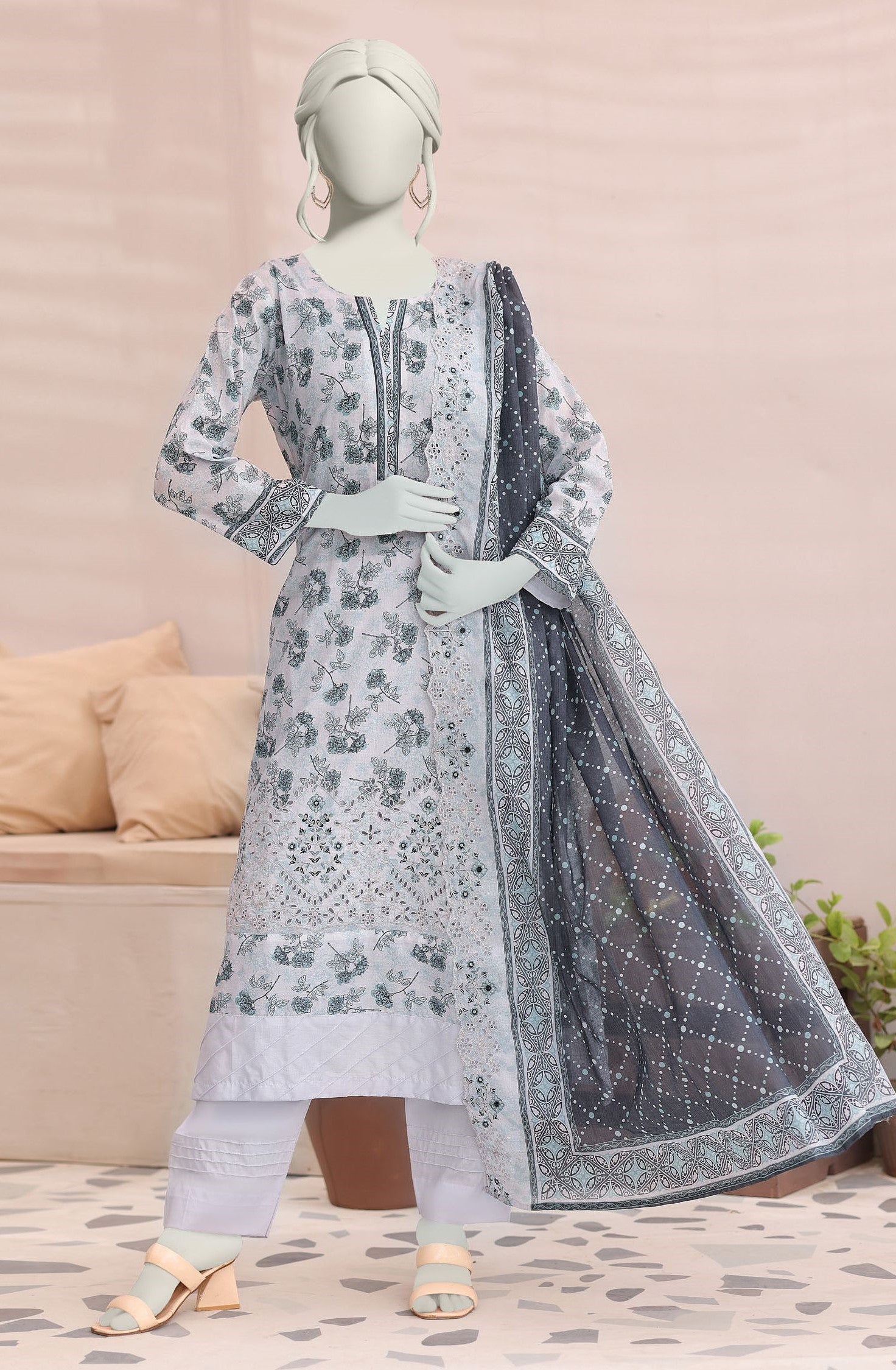 Mannequin wearing a floral dress with a dupatta in a room setting