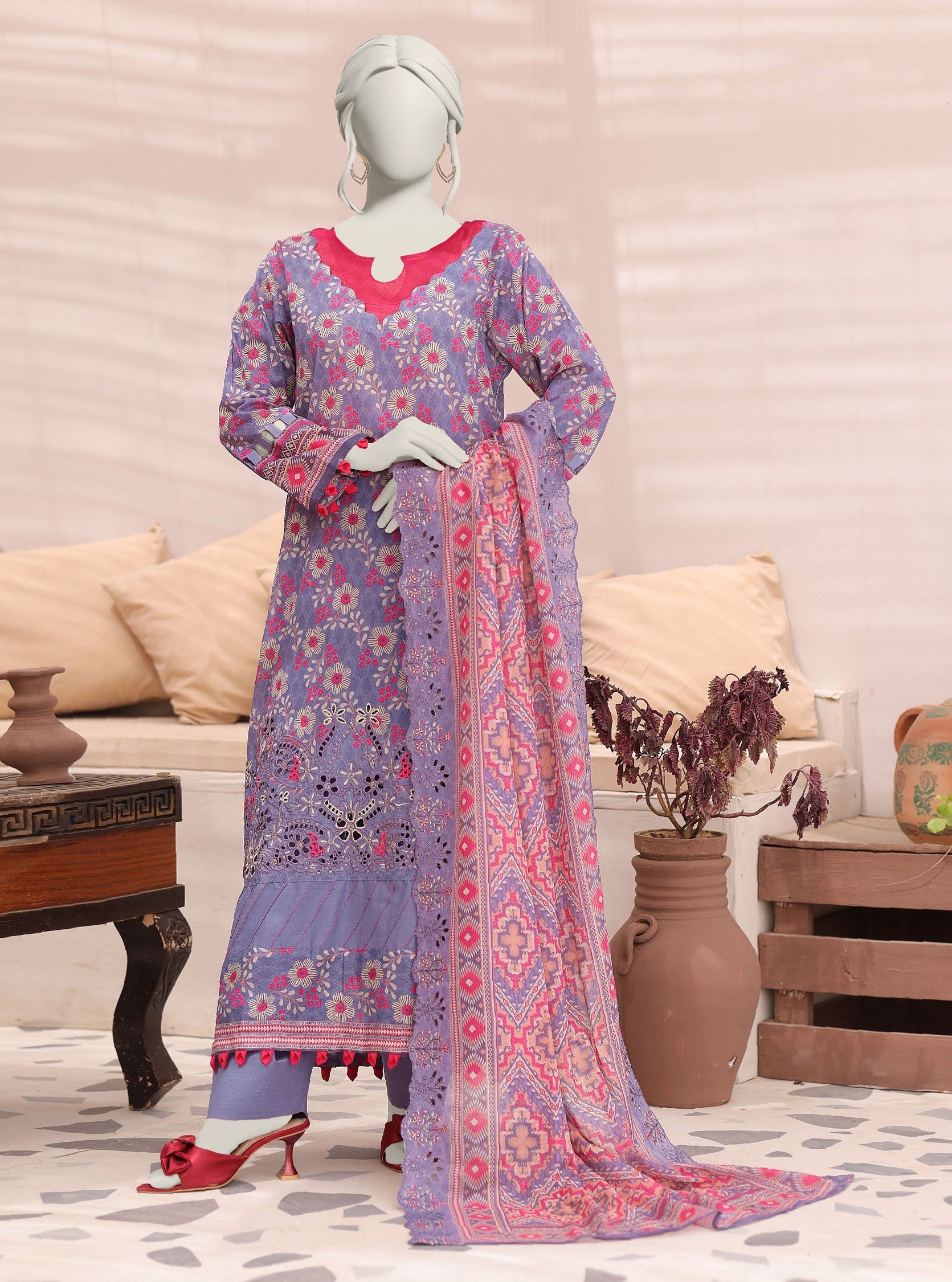 Mannequin wearing a floral dress with a matching dupatta in a living room setting.