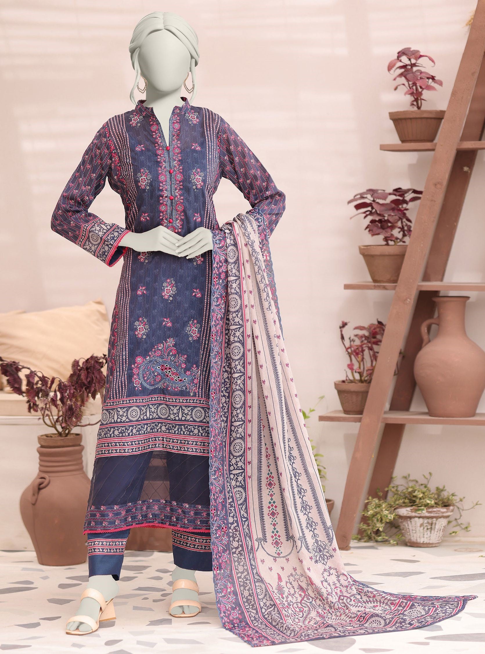 Mannequin wearing a traditional outfit with a patterned dress and dupatta in a home setting.