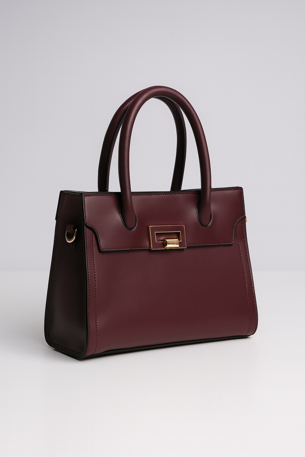 Maroon handbag with gold accents on a light gray background
