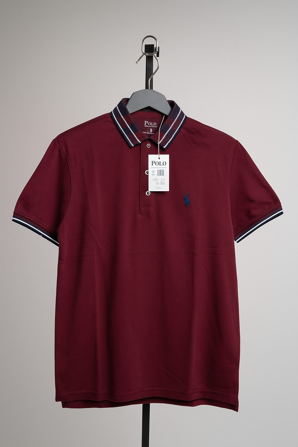Maroon polo shirt with white collar and trim on a hanger against a gray background