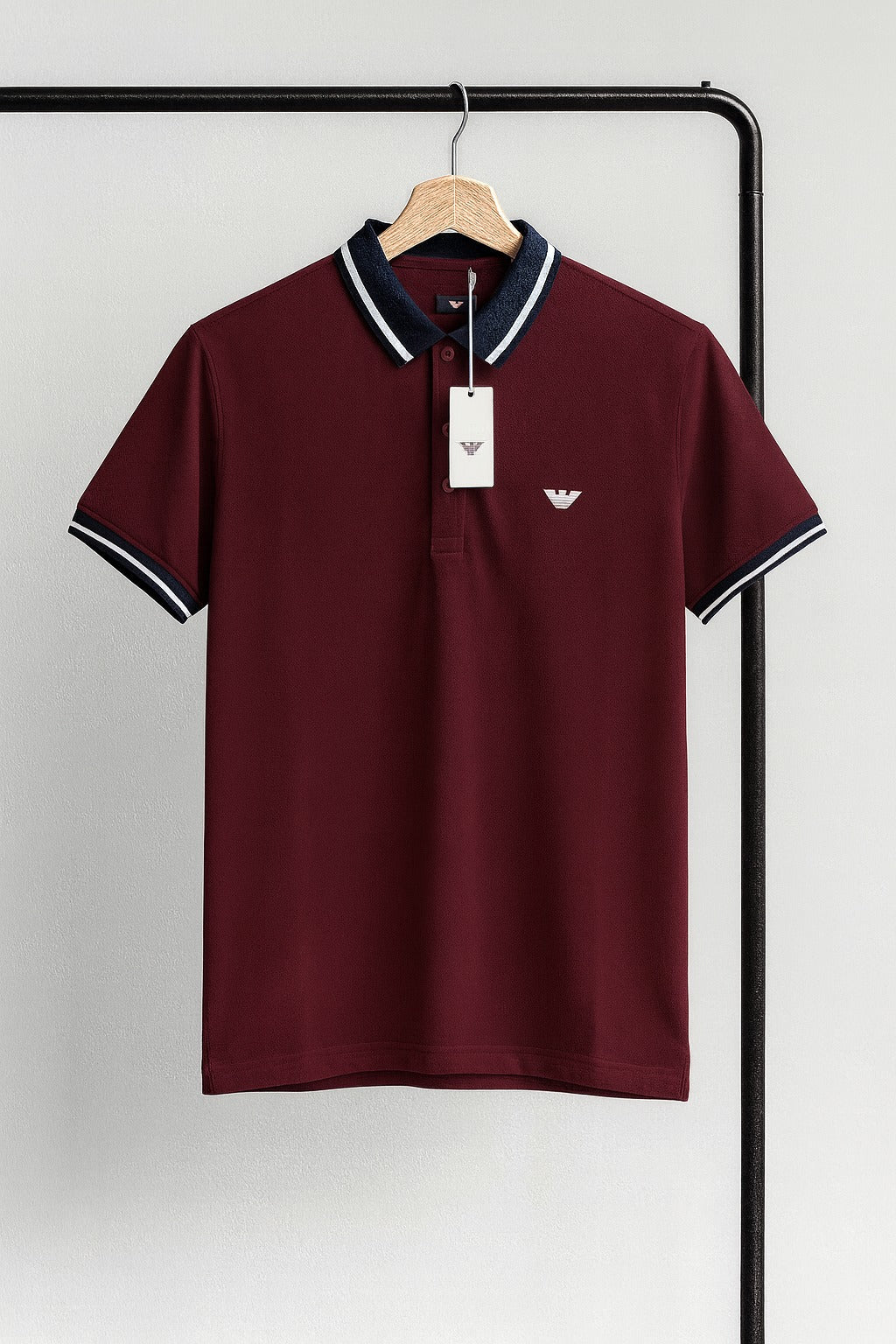 Maroon polo shirt with black trim on a hanger against a white background