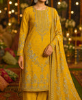 Mustard yellow embroidered traditional outfit with a matching dupatta against a festive background.