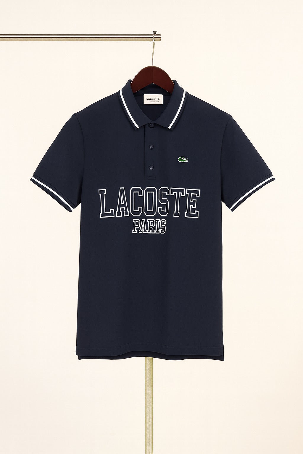 Navy blue Lacoste polo shirt on a hanger against a beige background