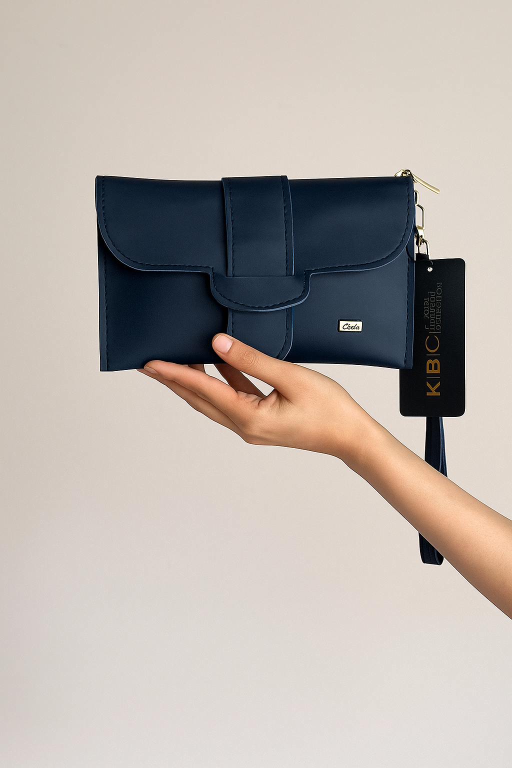 Navy blue clutch bag held by a hand with a beige background