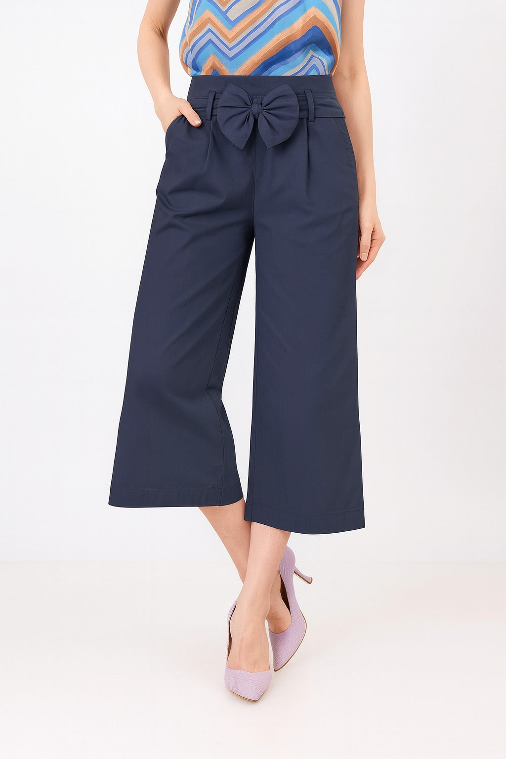 Navy blue wide-leg pants with a large bow detail worn by a person on a white background