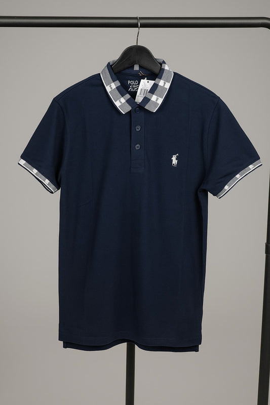 Navy blue polo shirt with plaid collar on a hanger against a gray background
