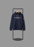 Navy hoodie with brand logo on a black stand against a gray background