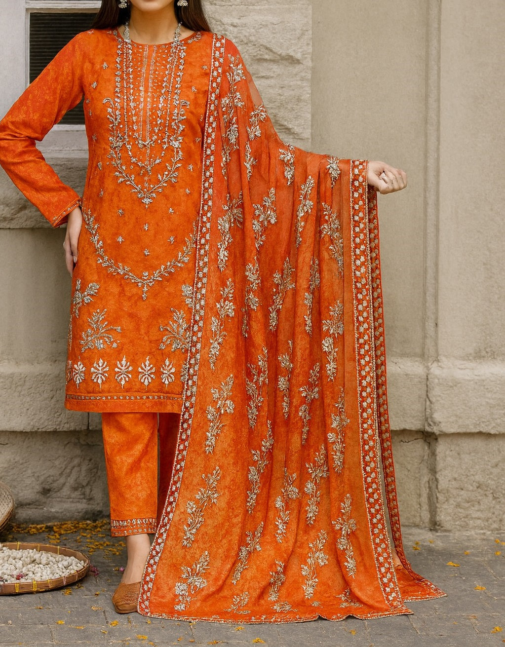 Orange embroidered traditional outfit with dupatta against a neutral background