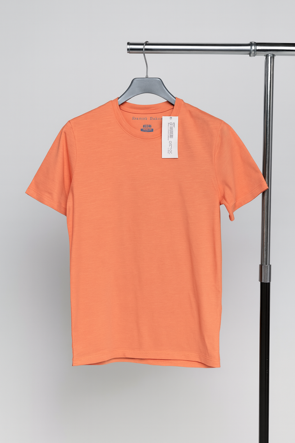 Orange t-shirt on a hanger against a gray background