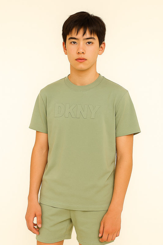 Person wearing a green DKNY t-shirt against a beige background