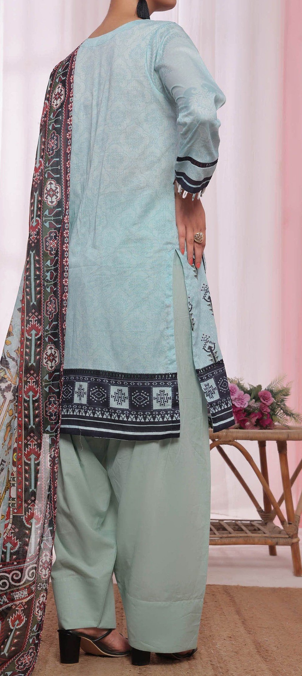 Person wearing a light blue traditional outfit with a patterned dupatta in a room setting.