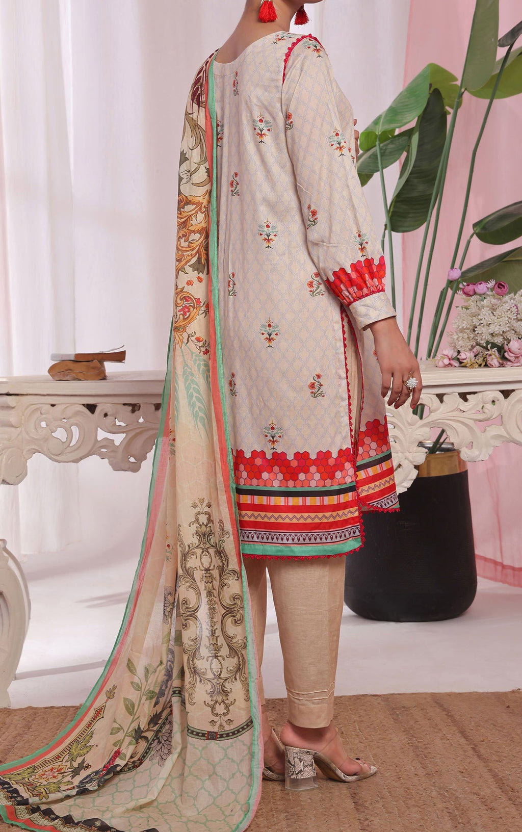 Person wearing a traditional outfit with a long dupatta in a decorative setting