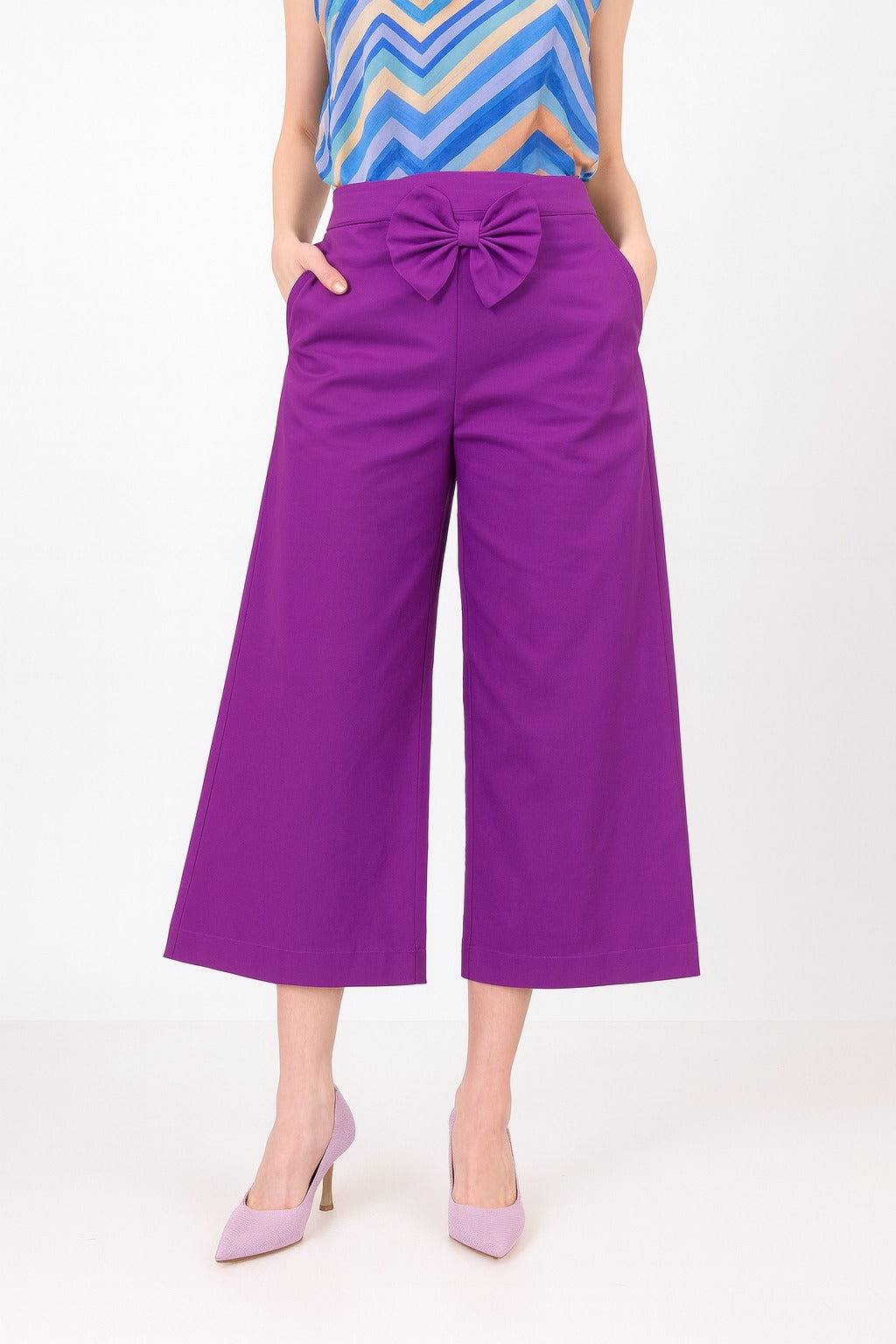 Purple wide-leg pants with a bow detail worn by a person on a white background
