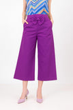 Purple wide-leg pants with a bow detail worn by a person on a white background