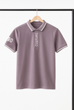 Purple polo shirt with text on a hanger against a white background