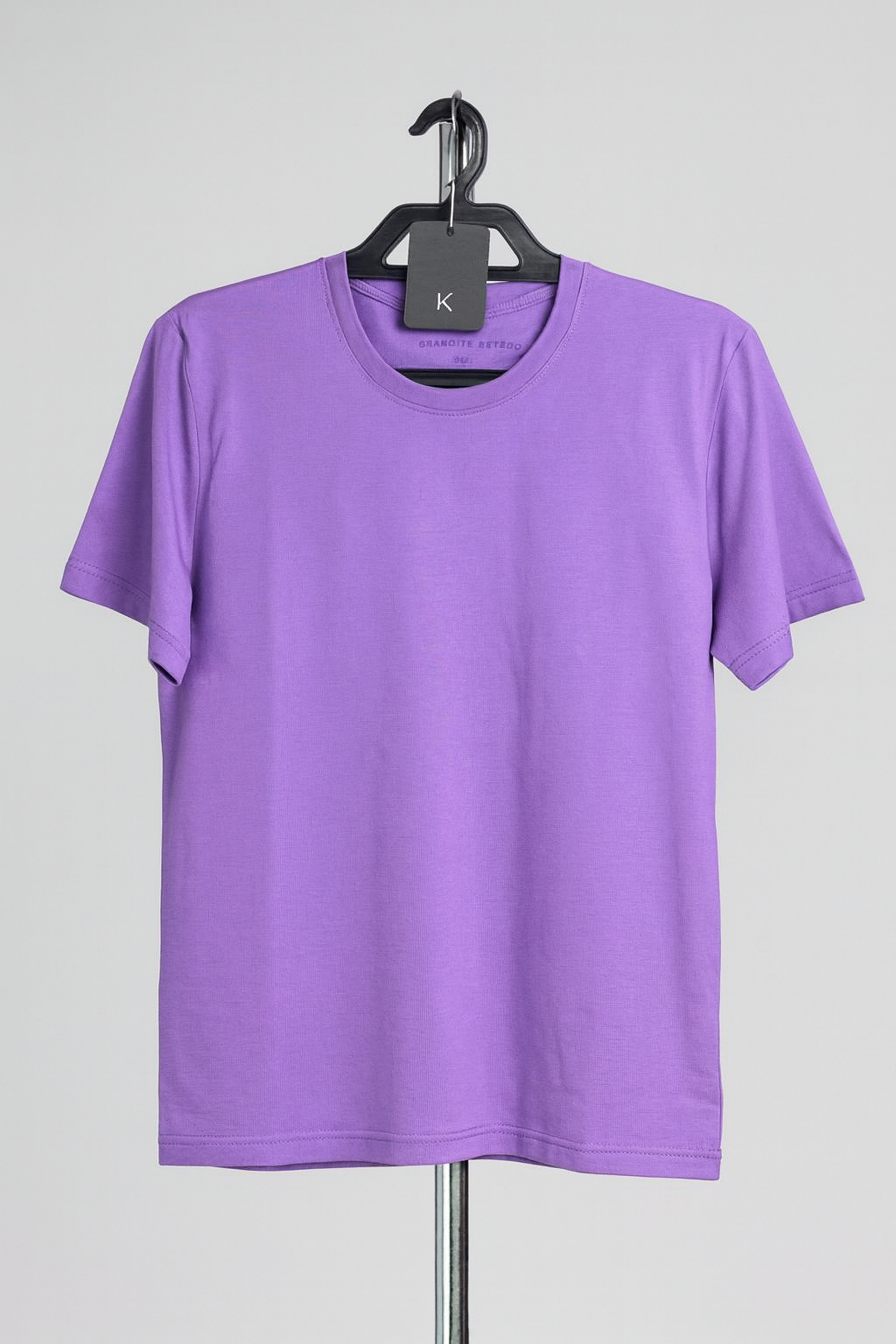 Purple t-shirt on a hanger against a gray background
