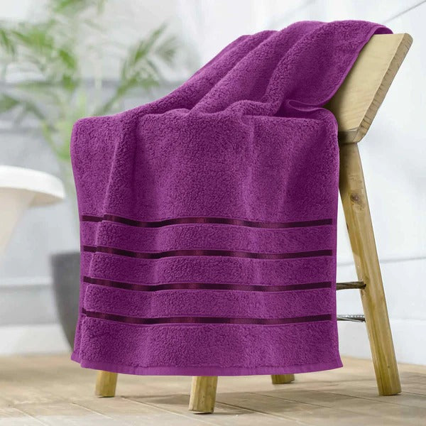 Purple towel with black stripes draped over a wooden stool indoors.