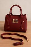 Red handbag with gold accents on a wooden surface
