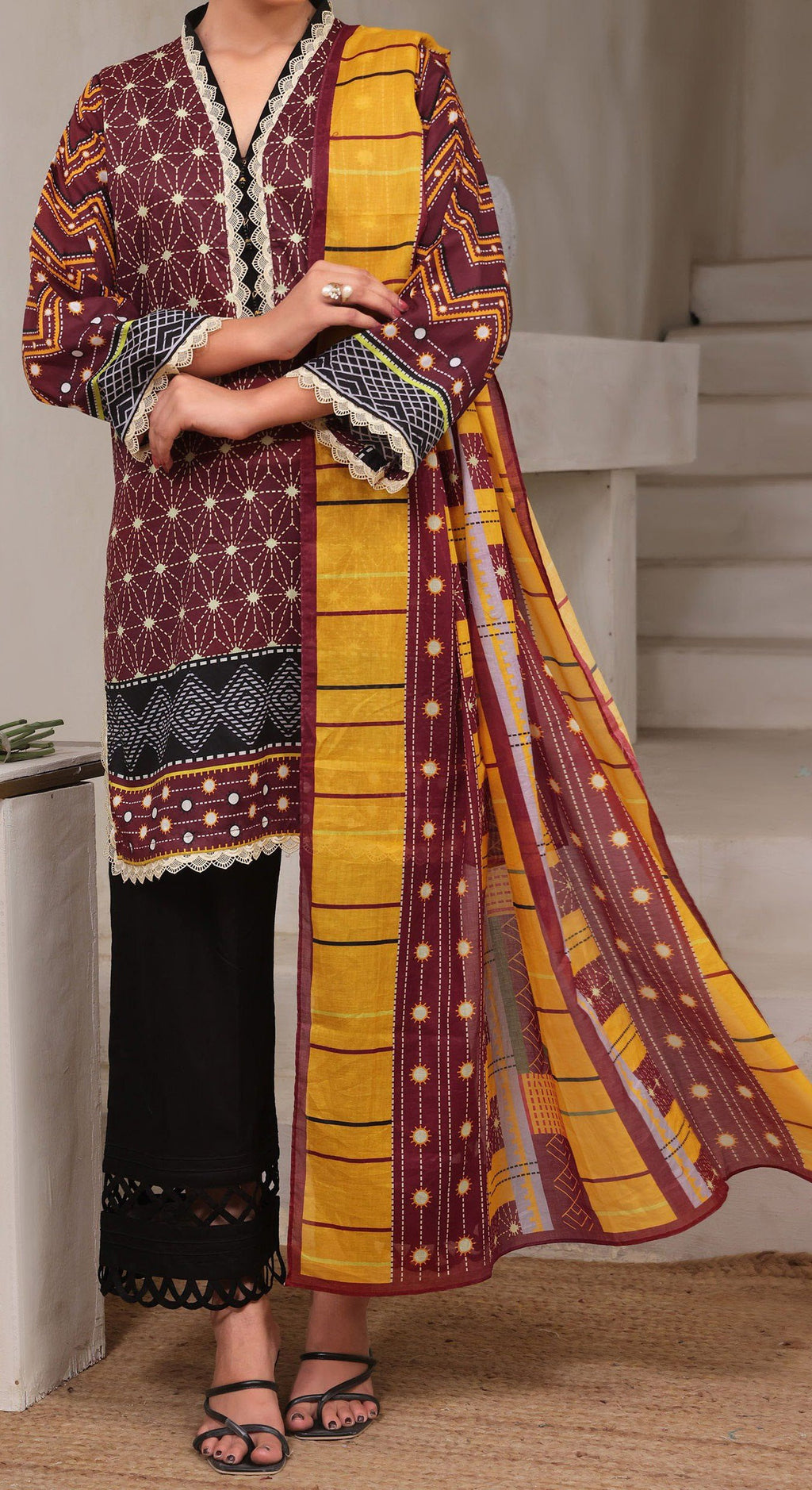 Traditional outfit with a patterned yellow and maroon dupatta draped over a person.