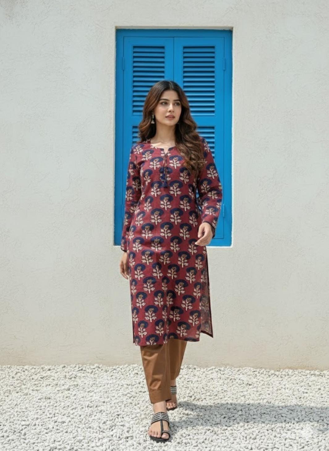 Woman wearing a patterned kurta with a blue shutter in the background