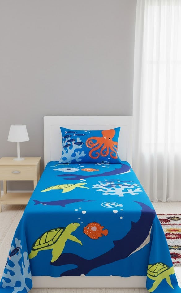 Children's bed with blue bedding featuring sea creature designs in a bedroom setting.