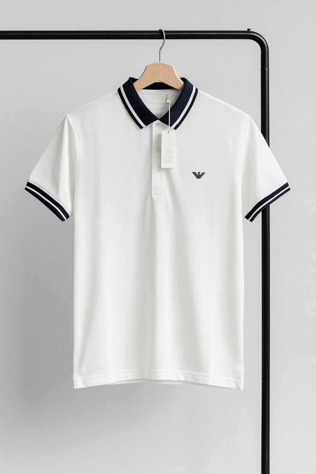 White polo shirt with black coller a hanger against a gray background