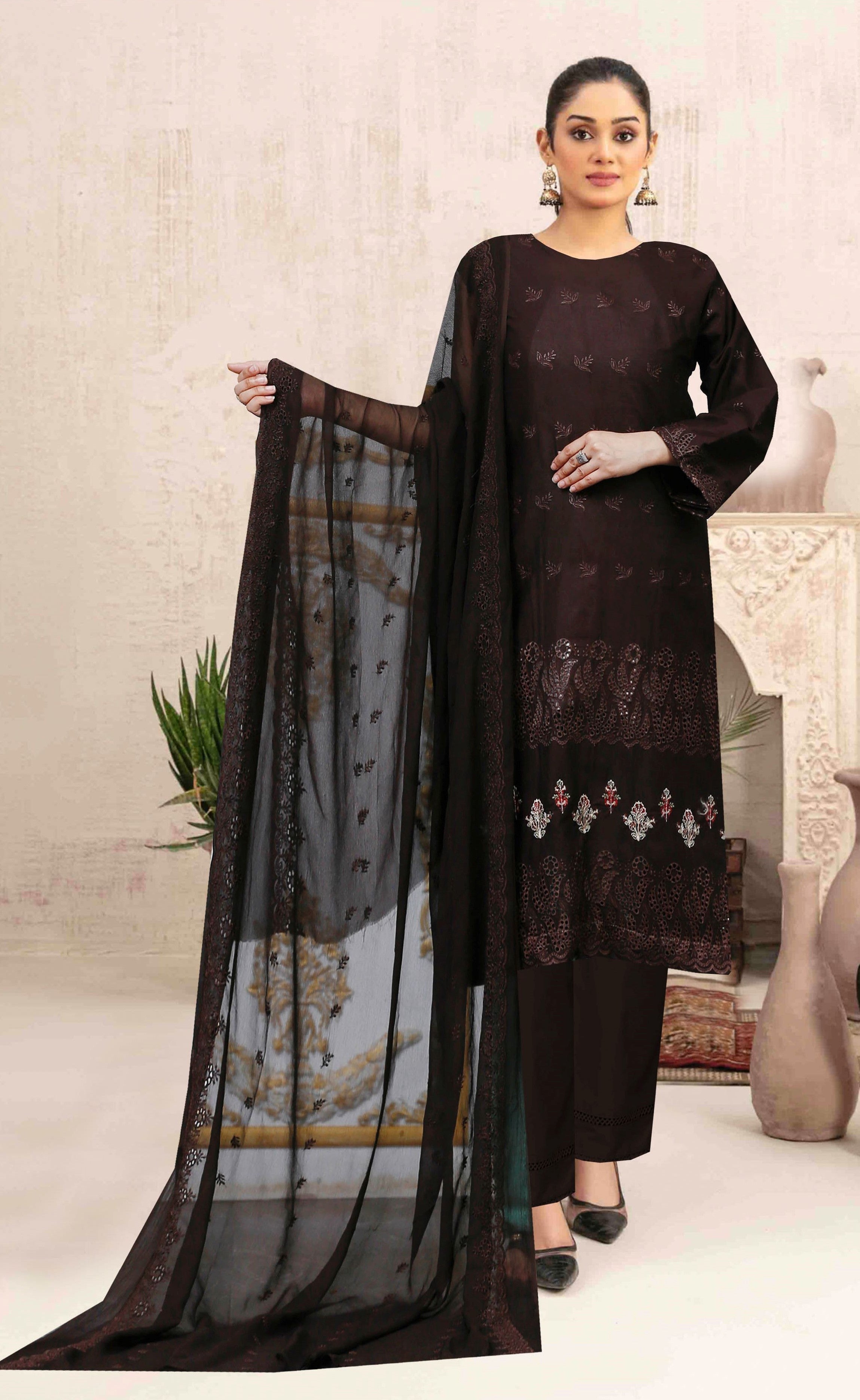 Woman holding a black dupatta with a patterned dress against a neutral background