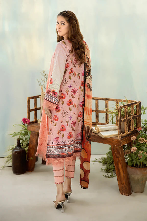 Woman in a pink floral dress standing in a decorative setting with plants and wooden furniture.