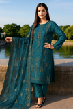 Woman in a teal traditional outfit with a matching dupatta by a lake.