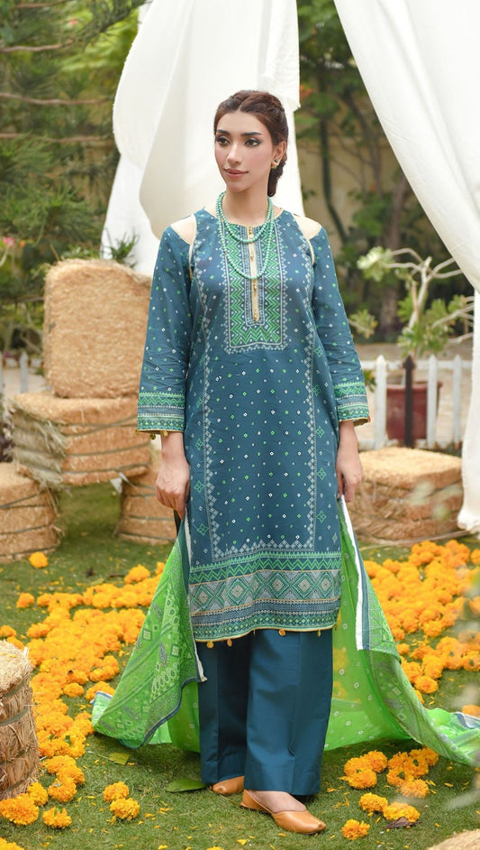 Woman in a traditional tealgreen and blue outfit standing in a decorated outdoor setting with flowers and white drapes.
