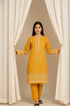 Woman in a yellow traditional outfit standing behind white curtains