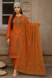 Woman in an orange traditional outfit with a matching dupatta, standing against a stone wall.