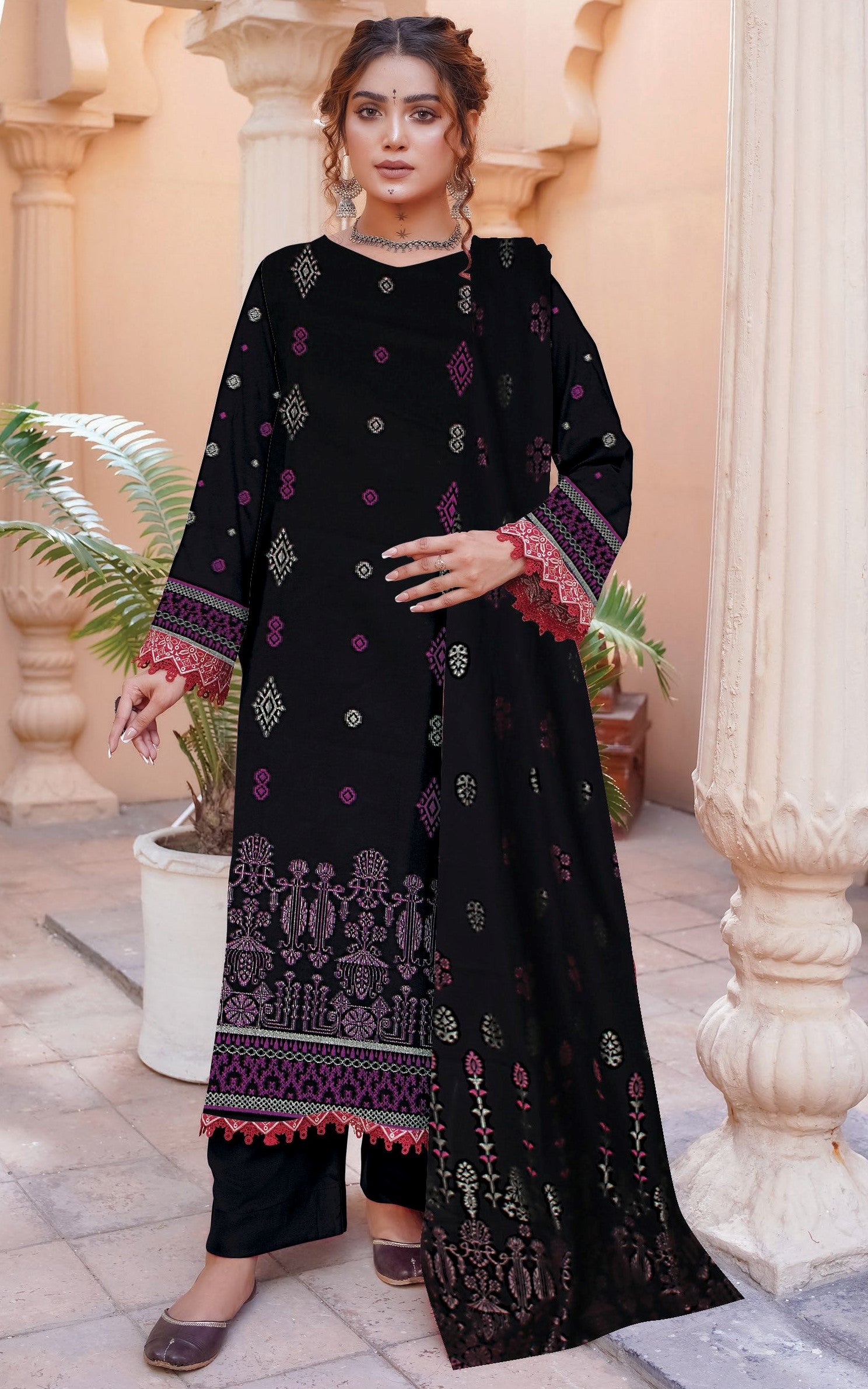 Woman wearing a black embroidered outfit with pink details in an outdoor setting.