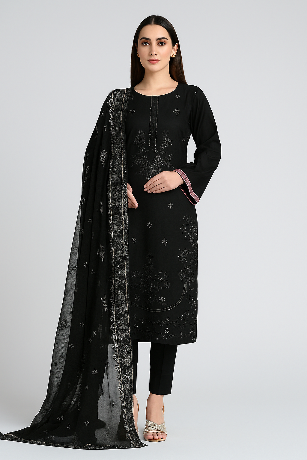 Woman wearing a black embroidered outfit with a matching dupatta on a white background