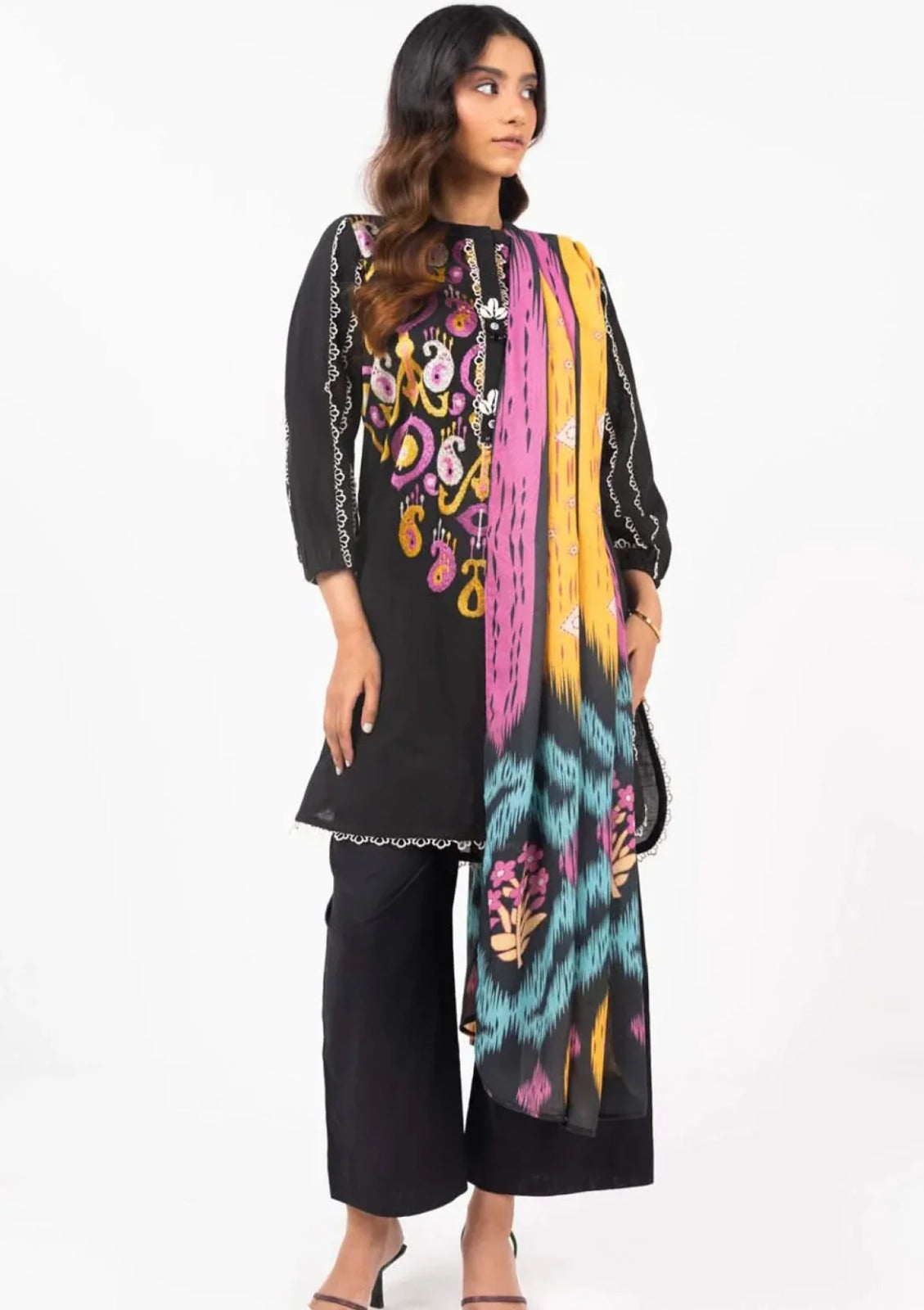 Woman wearing a black outfit with a colorful scarf on a white background