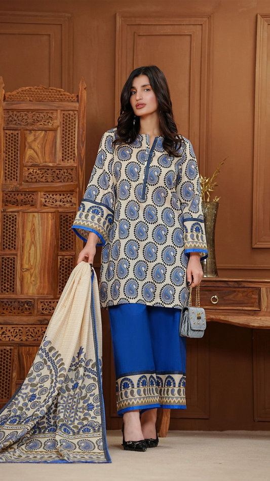 Woman wearing a blue and white patterned outfit with a matching dupatta in a wooden interior setting.