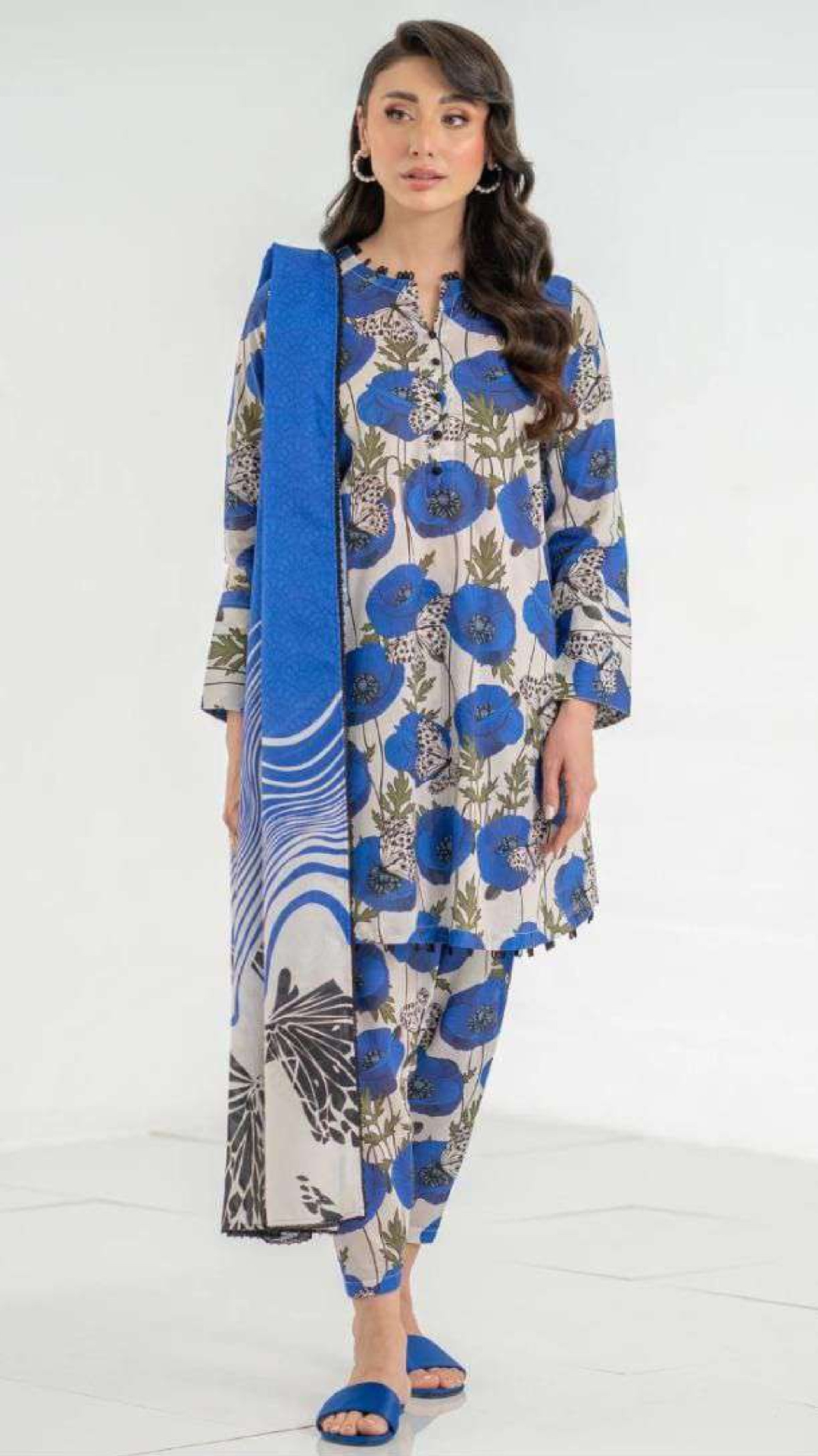 Woman wearing a blue floral traditional outfit with a white background