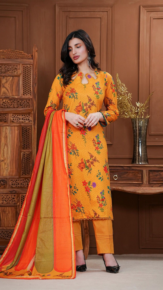 Woman wearing a bright yellow floral dress with an orange dupatta in a room with wooden paneling.