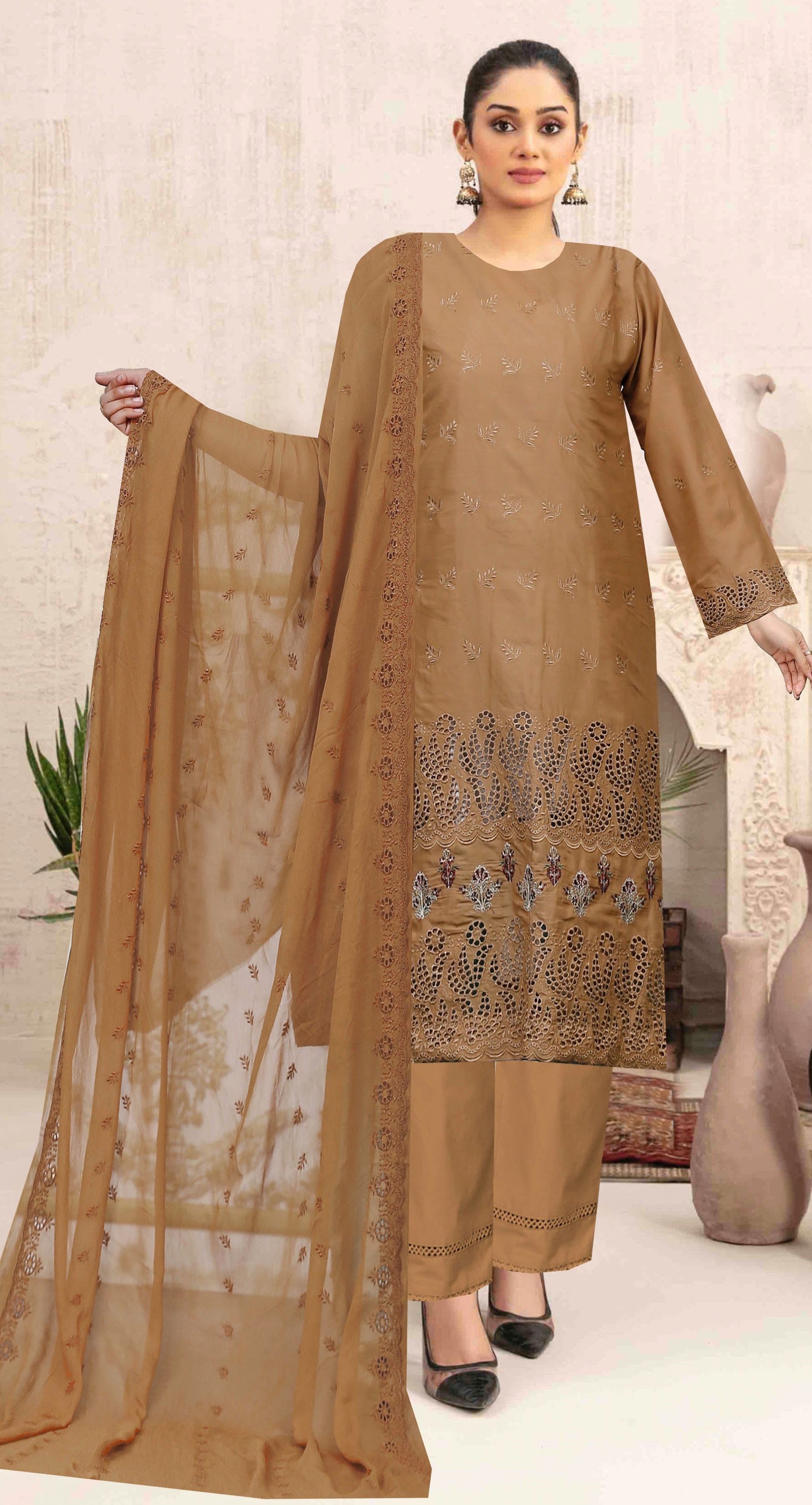 Woman wearing a brown traditional outfit with a matching dupatta in a minimal indoor setting.