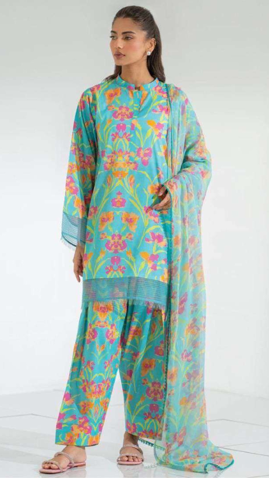 Woman wearing a colorful floral outfit on a white background