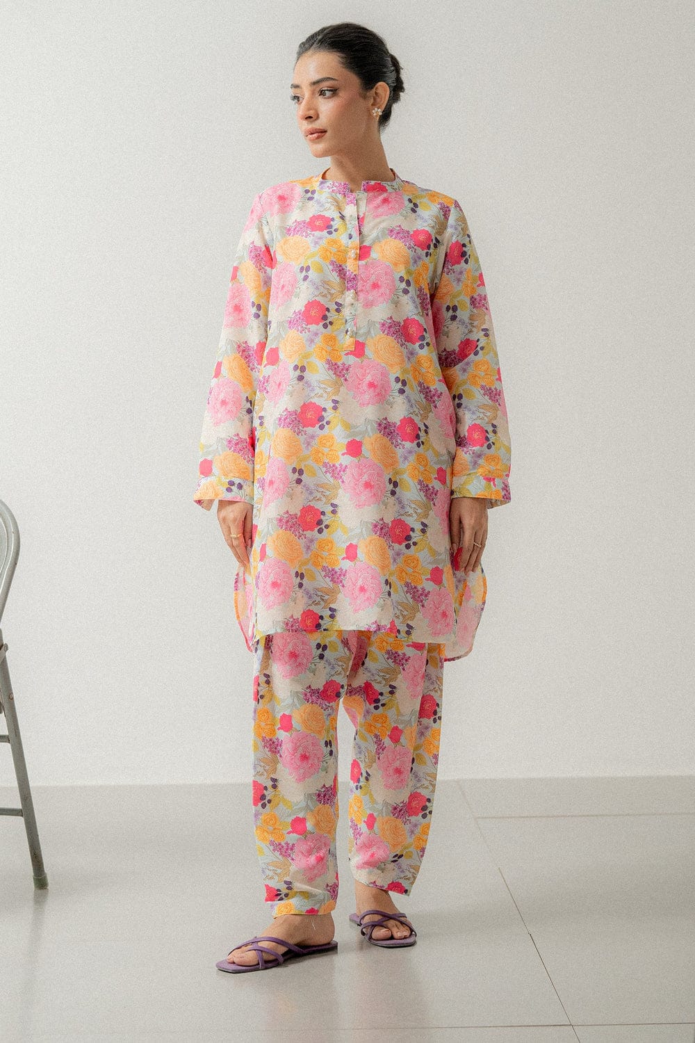 Woman wearing a colorful floral outfit on a white background
