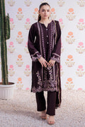 Woman wearing a dark purple embroidered outfit with a floral patterned wall in the background