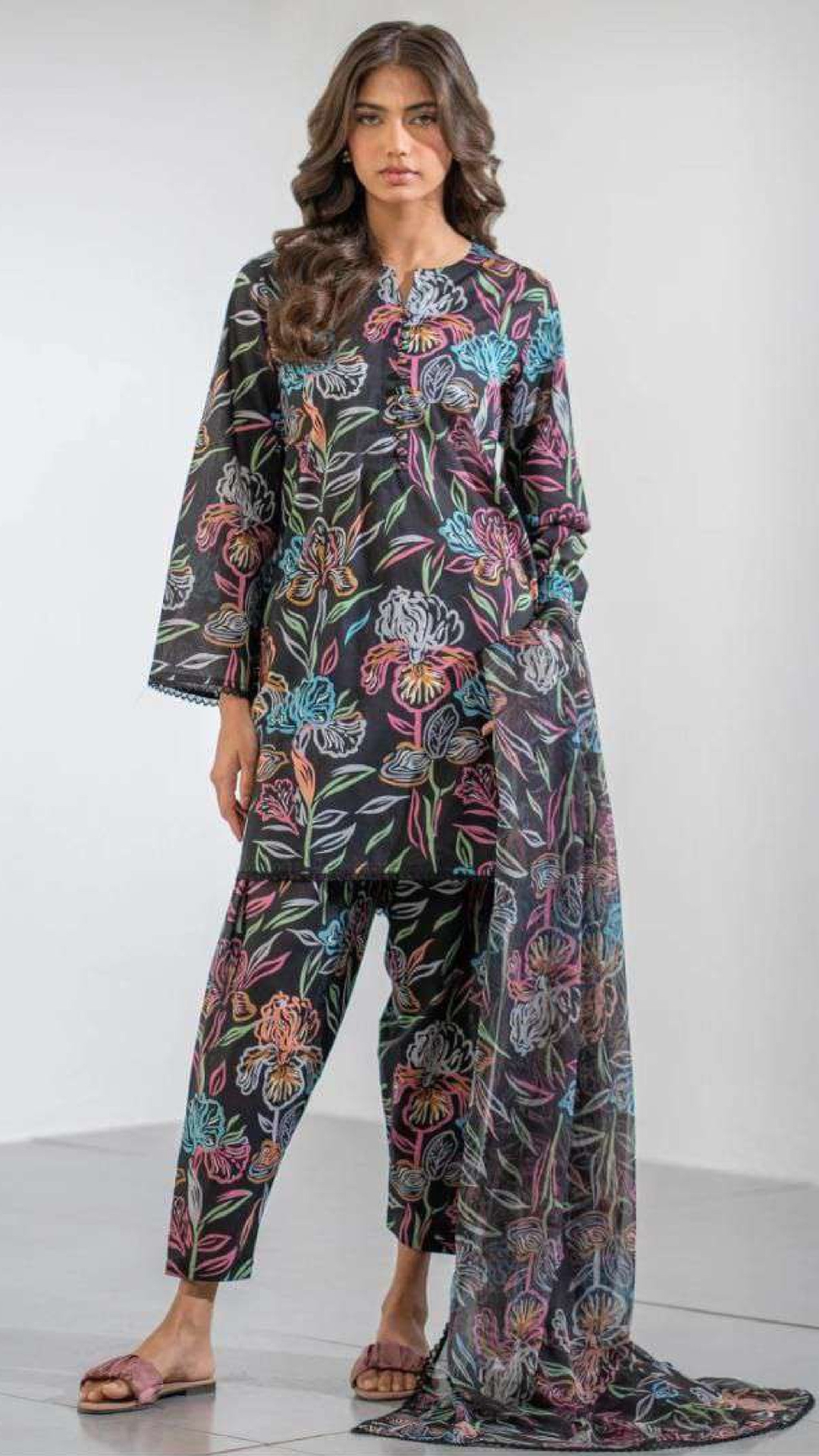 Woman wearing a floral dress and trouser set on a white background