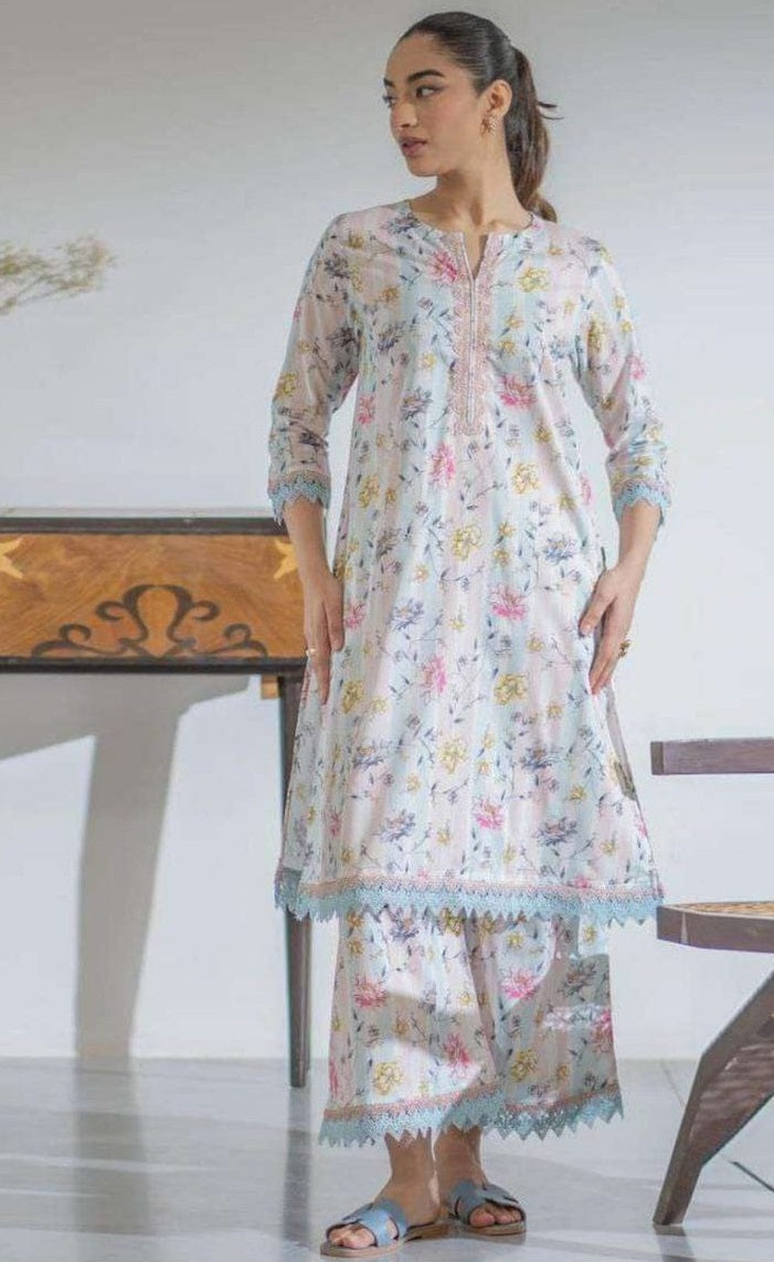 Woman wearing a floral dress standing in a minimalistic room.