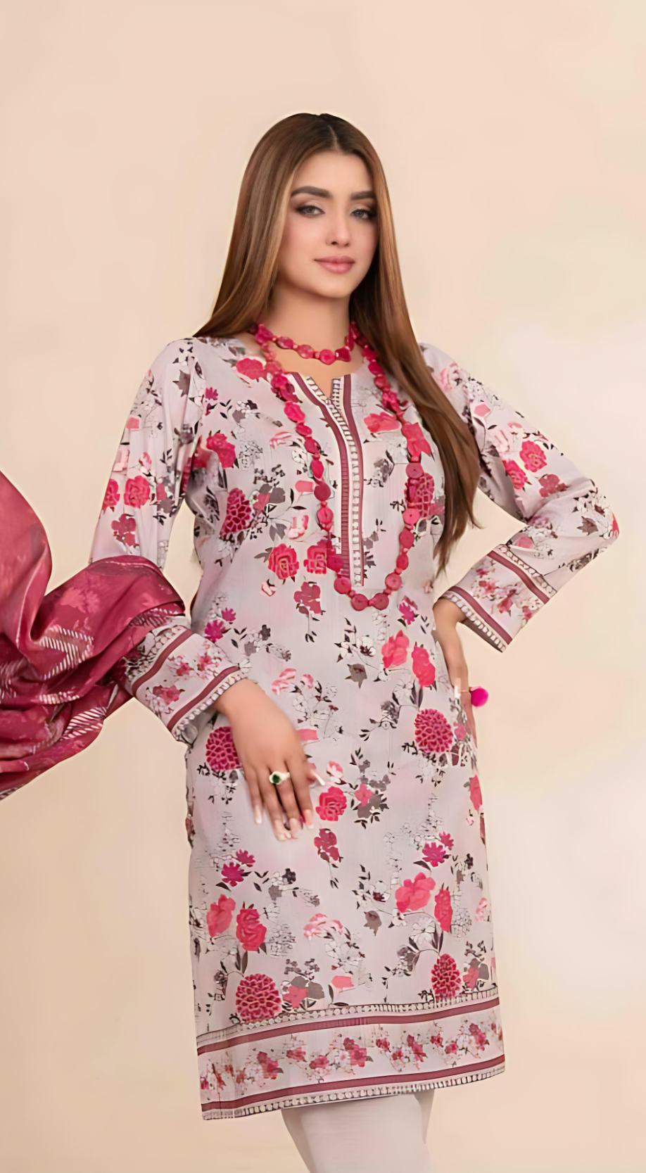 Woman wearing a floral dress with pink and red patterns on a beige background