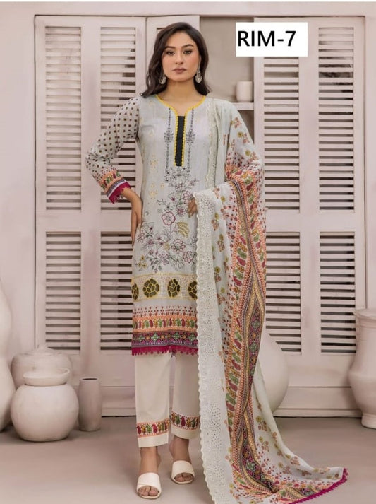 Woman wearing a floral embroidered outfit with a dupatta in a room with white shutters.