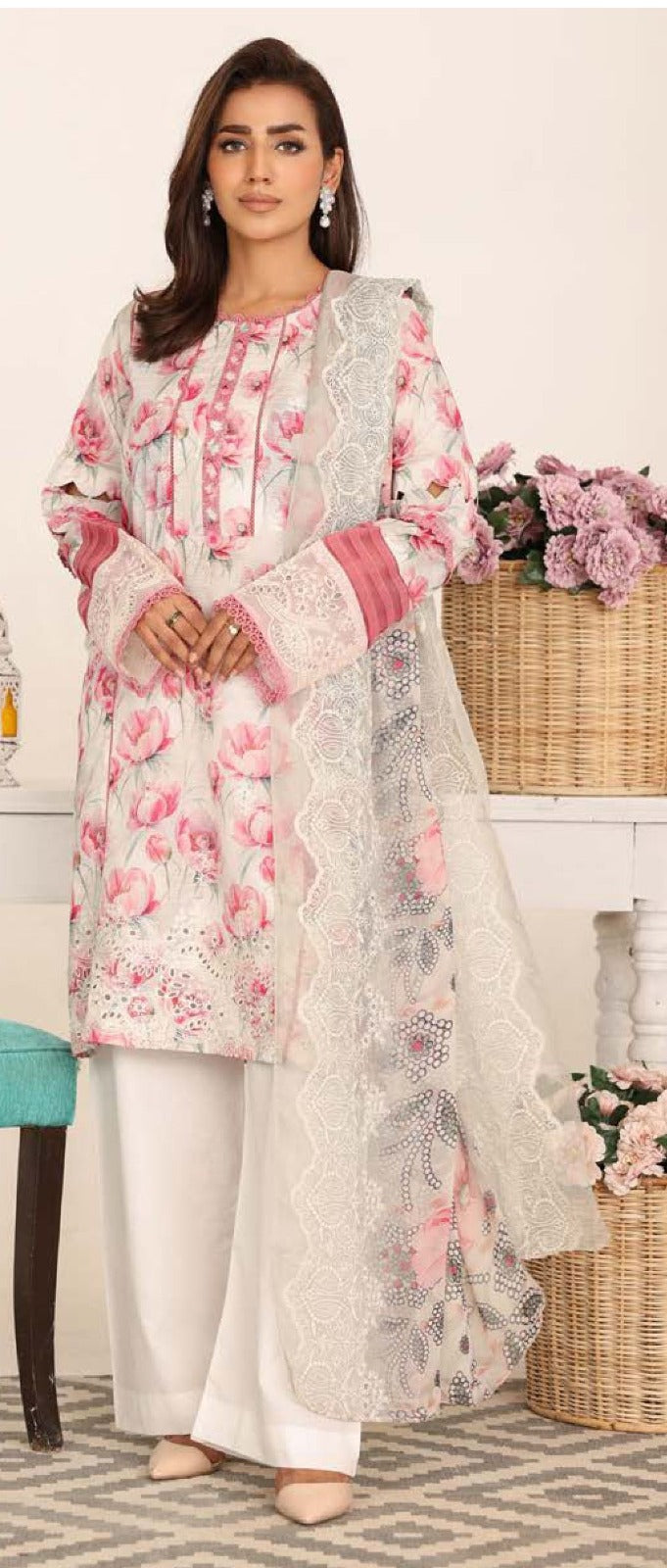 Woman wearing a floral embroidered outfit with a white background