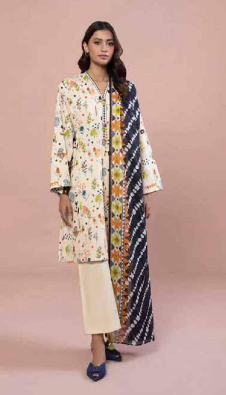 Woman wearing a floral kimono-style outfit on a pink background